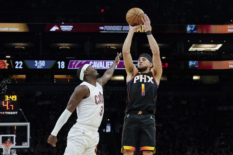 Devin Booker, base de los Suns de Phoenix, dispara frente a Caris LeVert, de los Cavaliers de Cleveland, en el duelo del miércoles 3 de abril de 2024 (AP Foto/Darryl Webb)