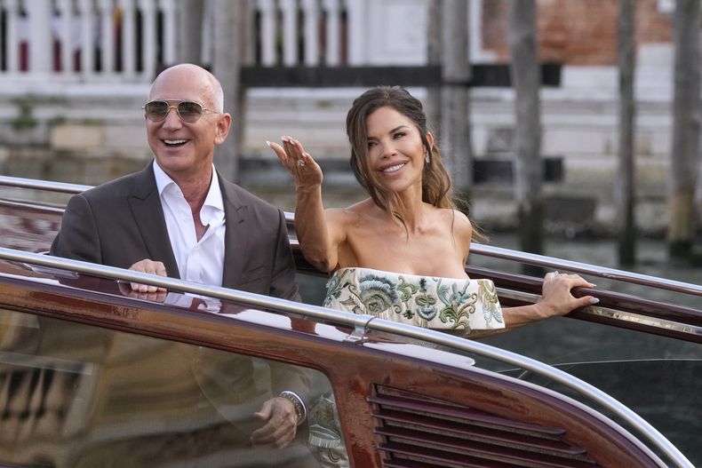 Jeff Bezos, izquierda, y Lauren Sanchez salen de un hotel para la recepción previa a su boda, en Venecia, Italia, el jueves 26 de junio de 2025. (Foto AP/Luca Bruno)