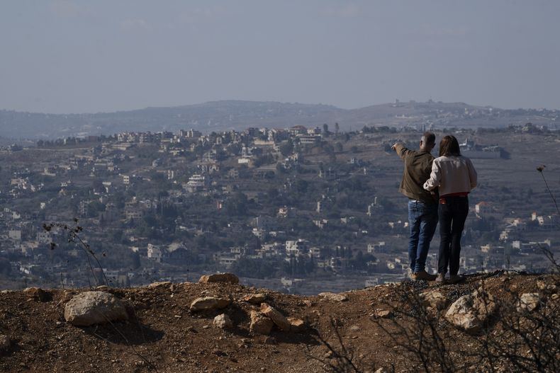 Una pareja israelí ve edificios en el sur del Líbano que han sido dañados en la guerra, desde el norte de Israel, el 30 de noviembre del 2024. (AP foto/Leo Correa)