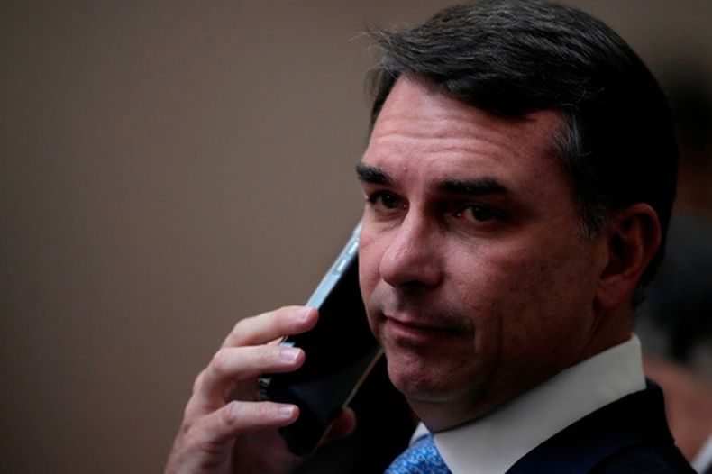 El senador Flavio Bolsonaro, hijo del expresidente brasileño Jair Bolsonaro, habla por teléfono al llegar a la ceremonia de toma de posesión de los jueces Nunes Marques y Andre Mendonca como presidente y vicepresidente, respectivamente, del Tribunal Superior Electoral en Brasilia, Brasil, el martes 12 de mayo de 2026. (AP Foto/Eraldo Peres)