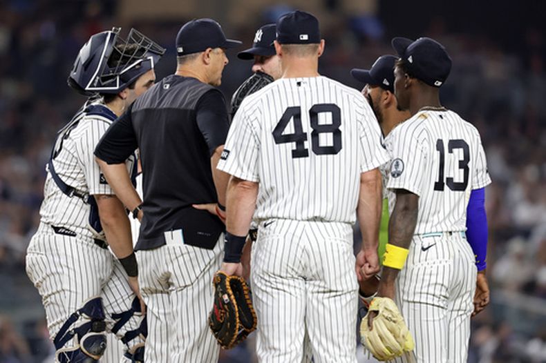 El mánager de los Yankees de Nueva York, Aaron Boone (segundo desde la izquierda), conversa con Gerrit Cole durante la séptima entrada de un partido de béisbol contra los Dodgers de Los Ángeles, el viernes 17 de julio de 2026, en Nueva York. (Foto AP/Adam Hunger)