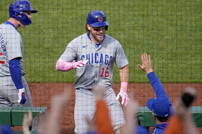 Patrick Wisdom (16), de los Cachorros de Chicago, regresa a la caseta después de batear jonrón de dos carreras frente al relevista de los Piratas de Pittsburgh Aroldis Chapman, durante la 10ma entrada del juego de béisbol del domingo 12 de mayo de 2024, en Pittsburgh. (AP Foto/Gene J. Puskar)