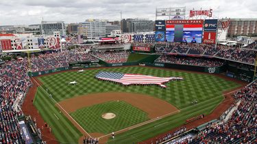 ARCHIVO - Esta fotografía de archivo del 4 de julio de 2013 muestra una bandera estadounidense, con la forma del país, en los jardines antes de un partido de béisbol entre los Nacionales de Washington y los Cerveceros de Milwaukee en el Nationals Park de Washington. El fiscal general de Washington demandó a StubHub, acusando a la plataforma de reventa de entradas de anunciar precios engañosamente bajos y luego aumentar los precios con tarifas adicionales. (Foto AP/Mark Tenally, archivo)