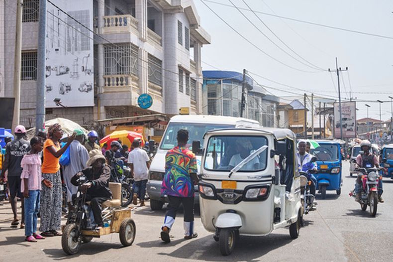 Hawa Mansaray lleva un pasajero en su vehículo, en una calle de Freetown, Sierra Leona, el 7 de marzo de 2026. (AP Foto/Abdul Hamid Kanu)