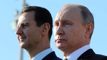 ARCHIVO - El presidente ruso, Vladímir Putin, a la derecha, y el presidente sirio, Bashar Assad, observan la marcha de las tropas en la base aérea de Hemeimeem, en Siria, el 11 de diciembre de 2017. (Mikhail Klimentyev, Sputnik, Kremlin Pool Photo via AP, Archivo)
