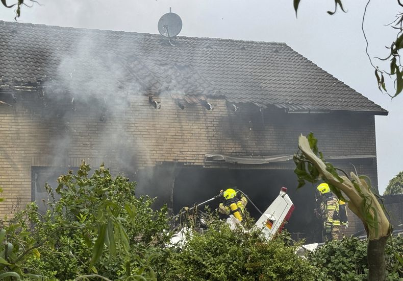 Bomberos trabajan en el sitio donde una avioneta se estrelló contra un edificio residencial, en Korschenbroich, Alemania, el sábado 31 de mayo de 2025. (Sascha Rixkens/Einsatzreport Niederrhein/dpa via AP)