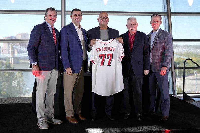 El nuevo mánager de los Rojos de Cincinnati Terry Francona sostiene su camiseta junto al presidente de operaciones Nick Krall, el dueño Bob Castellini y el gerente general Brad Meador en conferencia de prensa el lunes 7 de octubre del 2024. (AP Foto/Jeff Dean)