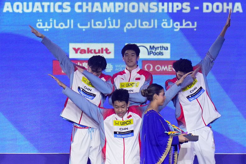 El equipo de china posa en el podio tras ganar la medalla de oro en el relevo 4x100 en el Campeonato Mundial en Doha, Qatar el domingo 11 de febrero del 2024. (AP Foto/Hassan Ammar)