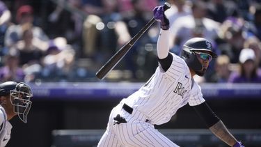 Harold Castro, de los Rockies de Colorado, pega un sencillo ante los Diamondbacks de Arizona, el domingo 30 de abril de 2023, en Denver. (AP Foto/David Zalubowski)