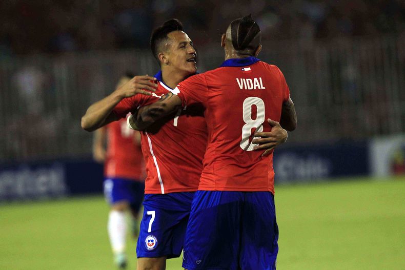 El jugador de la selecci&oacute;n de Chile y la Juventus, Arturo Vidal, de espa&ntilde;da, festeja con su compa&ntilde;ero Alexis S&aacute;nchez tras un gol de S&aacute;nchez ante Uruguay en un amistoso el martes, 18 de noviembre de 2014, en Santiago. (AP