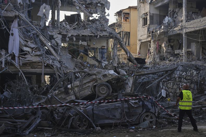 Miembros de las fuerzas de seguridad de Israel inspeccionan edificios residenciales destruidos por un misil lanzado por Irán, en Ramat Gan, cerca de Tel Aviv, Israel, el 14 de junio de 2025. (AP Foto/Ariel Schalit)
