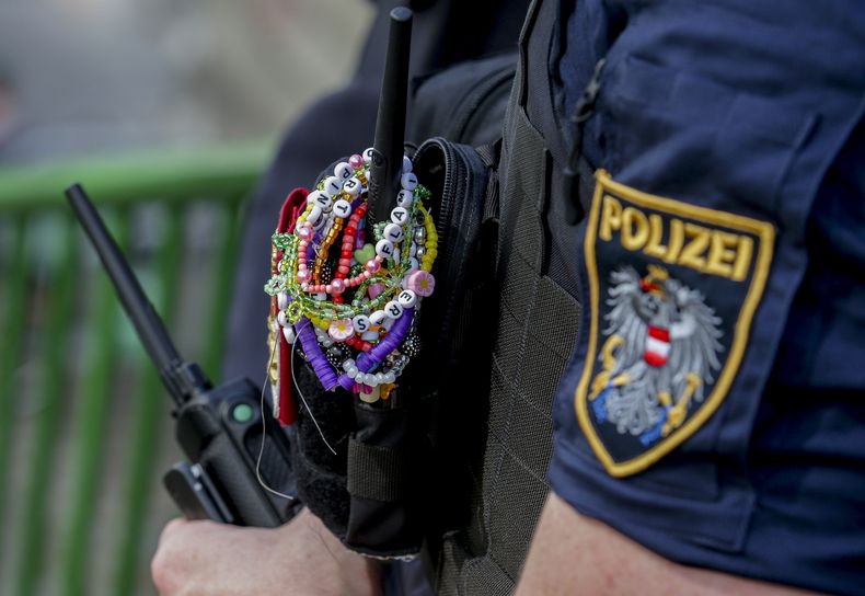 ARCHIVO - Un policía con brazaletes de la amistad de Taylor Swift vigila el centro de la ciudad de Viena el 8 de agosto de 2024. (Foto AP/Heinz-Peter Bader, archivo)