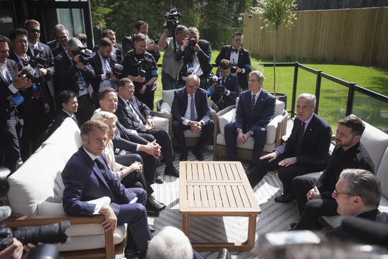 El primer ministro canadiense, Mark Carney, de espaldas segundo a la derecha, platica con el presidente ucraniano Volodymyr Zelenskyy (derecha) y otros mandatarios e invitados durante la cumbre del G7 en Kananaskis, Canadá, el martes 17 de junio de 2025. (Darryl Dyck/The Canadian Press via AP)