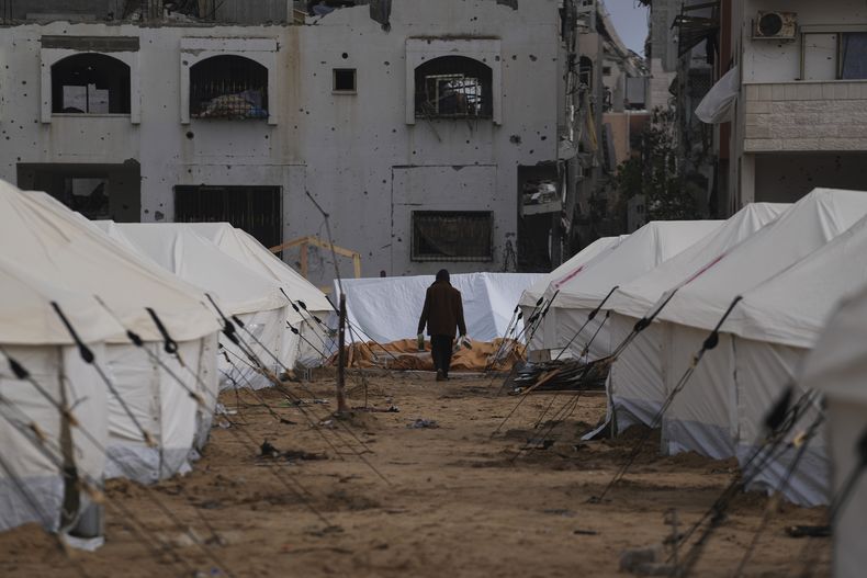 Un hombre camina entre tiendas de campaña para palestinos desplazados junto a edificios destruidos tras la ofensiva aérea y terrestre israelí en Jabaliya, Franja de Gaza, el 6 de febrero de 2025. (AP Foto/Abdel Kareem Hana, Archivo)