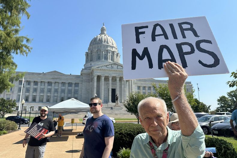 En la imagen, tomada con un teléfono inteligente, aparece Steve Perry, de Kansas City, con un letrero en el que se opone al plan de redistribución de distritos de Missouri, el miércoles 2 de septiembre de 2026, fuera del capitolio estatal, en Jefferson City, Missouri. (AP Foto/David A. Lieb)