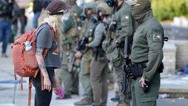 ARCHIVO - Una mujer se enfrenta a un agente del orden público que lleva un parche del Equipo de Respuesta Especial de la Oficina de Campo de Houston frente al edificio del Servicio de Inmigración y Control de Aduanas de Estados Unidos (ICE, por sus siglas en inglés) durante una protesta el sábado 14 de junio de 2025 en Portland, Oregon. (Foto AP/Jenny Kane, archivo)