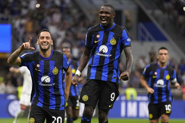 Hakan Calhanoglu y Marcus Thuram del Inter de Milan celebra tras el tercer gol de su equipo en la victoria ante la Fiorentina en la Serie A el domingo 3 de septiembre del 2023. (AP Foto/Antonio Calanni)