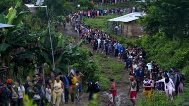 Migrantes que buscan llegar a Estados Unidos hacen fila para tomar un bote en Bajo Chiquito, en la provincia de Darién en Panamá, el jueves 5 de octubre de 2023, después de caminar a través de la selva del Darién desde Colombia. (AP Foto/Arnulfo Franco)