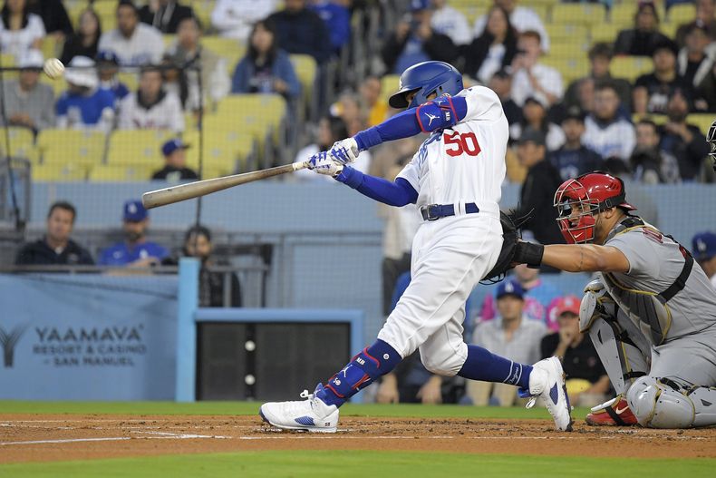 Mookie Betts (izquierda), de los Dodgers de Los Ángeles, conecta un jonrón solitario ante el catcher de los Cardenales de San Luis, Willson Contreras, en el primer inning del juego de la MLB que enfrentó a ambis equipos, el 28 de abril de 2023, en Los Ángeles. (AP Foto/Mark J. Terrill)