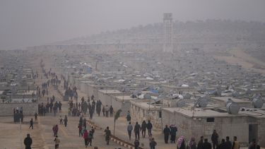 Sirios caminan en un campo de refugiados para desplazados dirigido por la Media Luna Roja de Turquía, el 26 de noviembre de 2021, en el distrito de Sarmada, al norte de la ciudad de Idlib, Siria. (AP Foto/Francisco Seco, archivo)