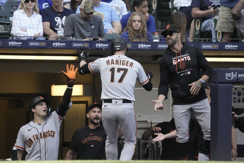 Mitch Haniger, de los Gigantes de San Francisco, vuelve a la cueva tras conseguir un jonrón de dos carreras en el octavo inning del juego ante los Cerveceros de Milwaukee, el sábado 27 de mayo de 2023 (AP Foto/Morry Gash)