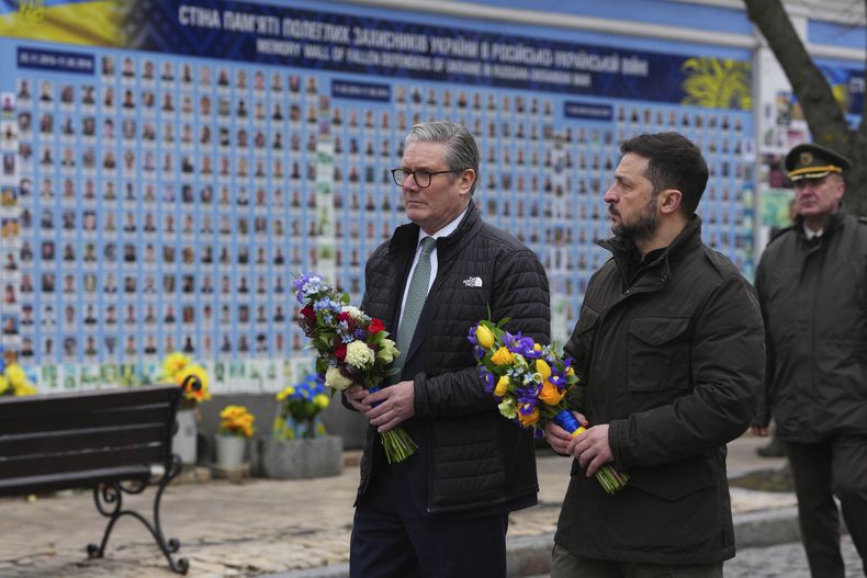 El primer ministro de Reino Unido, Keir Starmer, y el presidente de Ucrania, Volodymyr Zelenskyy, se disponen a depositar flores ante el Muro de Recuerdo a los Caídos por Ucrania, en Kiev, el 16 de enero de 2025. (Carl Court/Pool Foto vía AP)