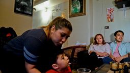 Rosa, segunda de la derecha, que pidió no revelar su apellido, una inmigrante indocumentada que recibía asistencia pero dejó de recibirla por temor a la deportación, con su hijo Edgar, a la extrema derecha y su nieto Logan, en su hogar en Nueva York, el 17 de mayo del 2017. (AP foto/Bebeto Matthews)