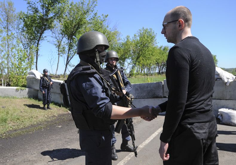 El primer ministro ucraniano Arseniy Yatsenyuk, derecha, saluda a soldados ucranianos en un control carretero en Slovyansk, Ucrania, el mi&eacute;rcoles 7 de mayo del 2014. (Foto AP/Andrew Kravchenko)