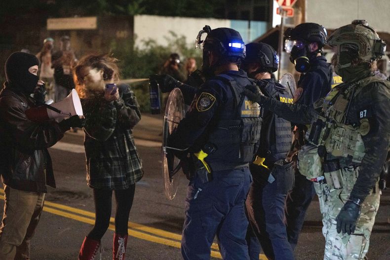 Una manifestante es rociada con un aerosol por un agente del Departamento de Seguridad Nacional en el exterior de una instalación del Servicio de Control de Inmigración y Aduanas, el 2 de octubre de 2025, en Portland, Oregon. (AP Foto/Jenny Kane)