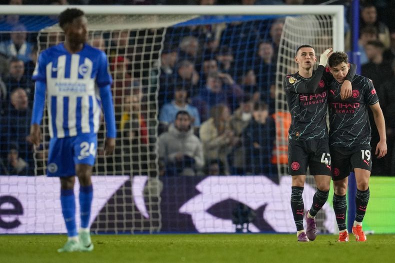 Julián Álvarez (derecha) celebra con Phil Foden tras anotar el cuarto gol del Manchester City en la victoria 4-0 ante Brighton en la Liga Premier, el jueves 25 de abril de 2024, en Brighton. (AP Foto/Kin Cheung)