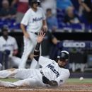 El venezolano Luis Arráez, de los Marlins de Miami, se desliza en el plato para anotar en el juego del martes 6 de junio de 2023, ante los Reales de Kansas City (AP Foto/Wilfredo Lee)