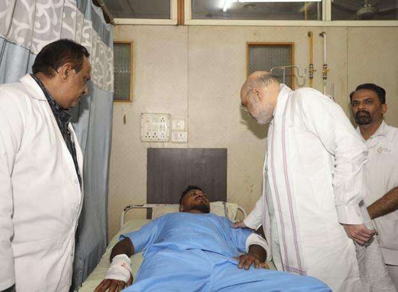 Esta fotografía proporcionada por el Ministerio del Interior de la India muestra al ministro de la dependencia, Amit Shah, con el sobreviviente del choque del avión de Air India, Viswashkumar Ramesh, de 40 años de edad, en el hospital de Ahmedabad, India. (Ministerio del Interior de la India vía AP)