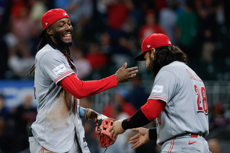 El pelotero de los Rojos de Cincinnati, Elly De La Cruz (izquierda), y Eugenio Suárez (28) celebran tras derrotar a los Bravos de Atlanta durante la novena entrada de un partido de béisbol, el 22 de septiembre de 2026, en Atlanta. (Foto AP/Erik S. Lesser)