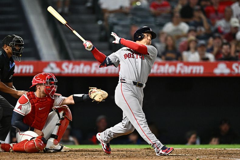 Masataka Yoshida, derecha, de los Medias Rojas de Boston, batea un sencillo productor durante la séptima entrada del juego de béisbol de Grandes Ligas contra los Angelinos de Los Ángeles, el domingo 5 de julio de 2026, en Anaheim, California. (AP Foto/William Liang)