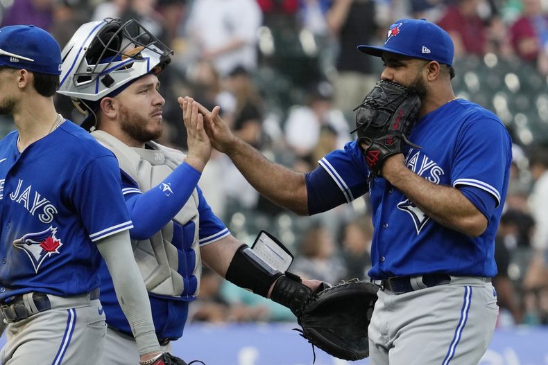 El relevista de los Azulejos de Toronto Yimi Garcia celebra con el cátcher Alejandro Kirk tras la victoria ante los Medias Blancas de Chicago en el primer juego de una doble cartelera el jueves 6 de julio del 2023. (AP Foto/Nam Y. Huh)