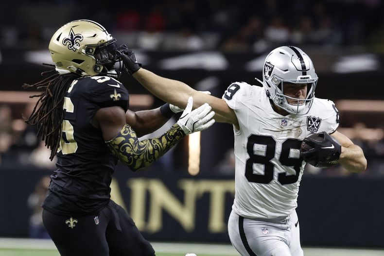 El tight end de los Raiders de Las Vegas Brock Bowers corre mientras lo defiende el linebacker de los Saints de Nueva Orleans Demario Davis en el encuentro del domingo 29 de diicembre del 2024. (AP Foto/Butch Dill)