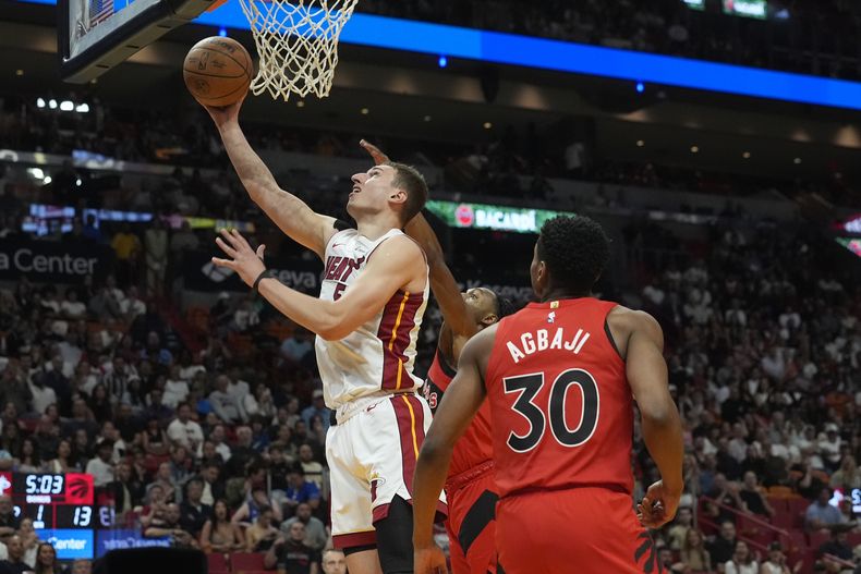 Nikola Jovic, del Heat de Miami, salta para encestar ante Ochai Agbaji, de los Raptors de Toronto, el viernes 12 de abril de 2024 (AP Foto/Marta Lavandier)