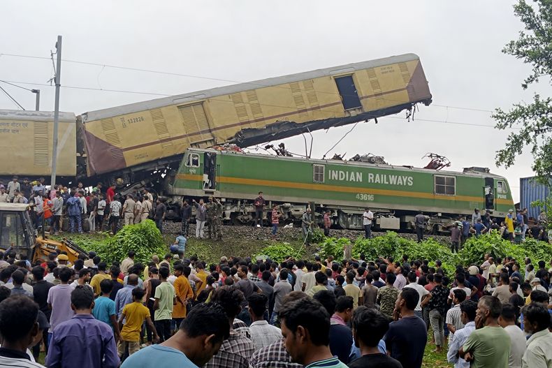 Gente mira trabajar a los rescatistas trabajan tras un choque después de que un tren de mercancías contra el expreso de Kanchanjunga, un tren de pasajeros, cerca de la estación de Nueva Jalpaiguri, en el estado de Bengala Occidental, India, el lunes 17 de junio de 2024. (AP Foto/Diptendu Dutta)