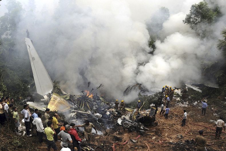 ARCHIVO - Civiles observan a bomberos y rescatistas trabajar en el lugar donde se estrelló un avión de Air India en Mangalore, en el estado de Karnataka, en el sur de India, el sábado 22 de mayo de 2010. (AP Foto, archivo)