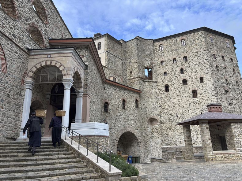 ARCHIVO - Monjes cargan con cestas de suministros hasta el monasterio Simonos Petra, en la comunidad autosostenible de monjes Agion Oros, en la península del Monte Athos, en el norte de Grecia, el 15 de abril de 2025. (AP Foto/Thanassis Stavrakis, archivo)