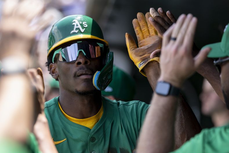 Denzel Clarke, de los Atléticos, celebra en el dugout después de anotar durante la segunda entrada de un juego de béisbol contra los Orioles de Baltimore, el domingo 8 de junio de 2025, en West Sacramento, California. (Foto AP/Sara Nevis)