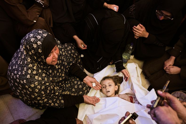 Familiares en duelo rodean el cuerpo de Menna Allah Abu Labda, una niña palestina de 6 años que murió en un ataque aéreo israelí, durante su funeral en el Hospital Nasser, el lunes 25 de mayo de 2026, en Jan Yunis, Franja de Gaza. (AP Foto/Abdel Kareem Hana)