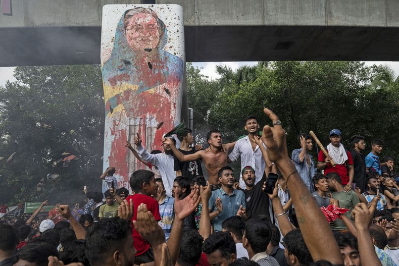ARCHIVO - Manifestantes celebran junto a un retrato desfigurado de la primera ministra Sheikh Hasina después de la noticia de su renuncia, en Daca, Bangladesh, el 5 de agosto de 2024. (AP Foto/Fatima Tuj Johora, Archivo)