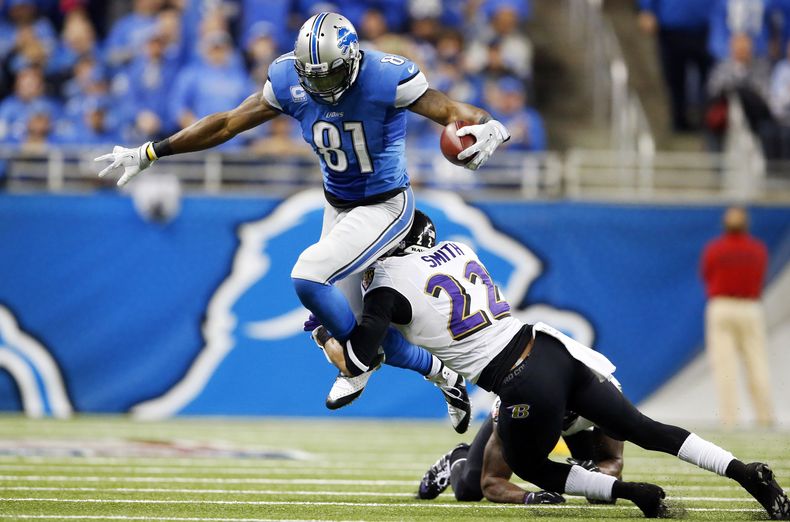 El cornerback Jimmy Smith (22), de los Ravens de Baltimore, derriba al wide receiver Calvin Johnson (81), de Lions de Detroit, en el tercer cuarto del juego de NFL en Detroit, el 16 de diciembre de 2013. Los Ravens ganaron 18-16. (Foto AP/Paul Sancya)