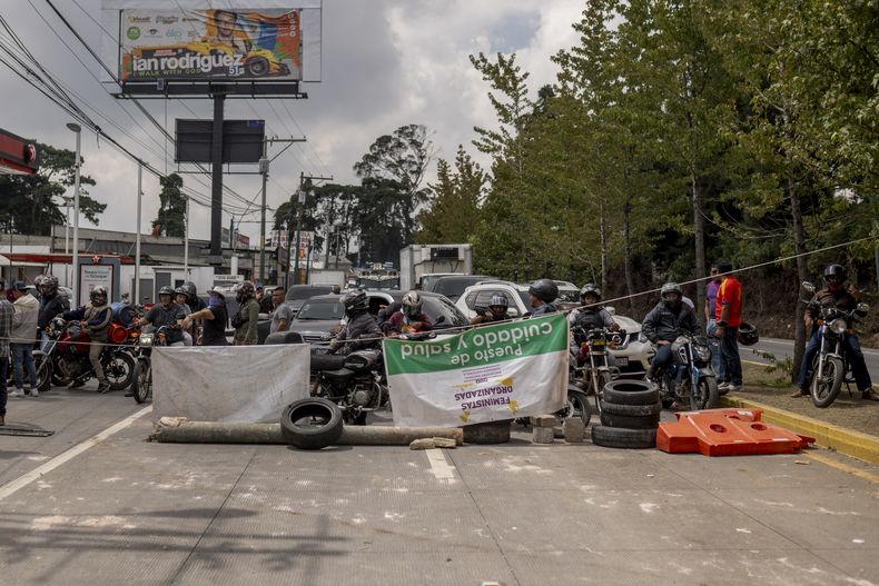 Varias personas bloquean la Carretera Panamericana el viernes 13 de octubre de 2023, en San Lucas Sacatepéquez, Guatemala, para exigir la renuncia de la fiscal general Consuelo Porras. (AP Foto/Santiago Billy)
