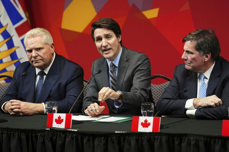 El primer ministro de Ontario, Doug Ford (izquierda), y el ministro de Asuntos Intergubernamentales, Dominic Leblanc (derecha), observan al primer ministro canadiense Justin Trudeau durante una conferencia de prensa, en Ottawa, Canadá, el miércoles 15 de enero de 2025. (Sean Kilpatrick/The Canadian Press vía AP)