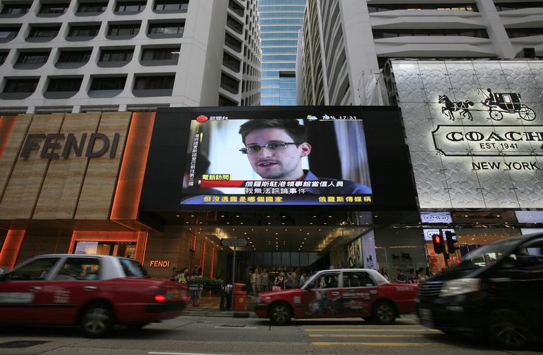 Una pantalla gigante de noticias en Hong Kong muestra la imagen del ex empleado de la Agencia de Seguridad Nacional de EEUU Edward Snowden, quien revel&oacute; la existencia de programas de espionaje a nivel global, el 23 de junio de 2013. (Foto AP/Vincen