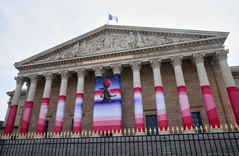 La Asamblea Nacional de Francia, cubierta con la obra Marianne rêve (Sueños de Marianne) del artista callejero francés Seth, que representa a Marianne, el símbolo de la República Francesa, antes de que los legisladores voten sobre la aprobación final de un proyecto de ley que permitiría que los adultos con enfermedades incurables reciban medicación letal, en París, el miércoles 15 de julio de 2026. (AP Foto/Michel Euler)