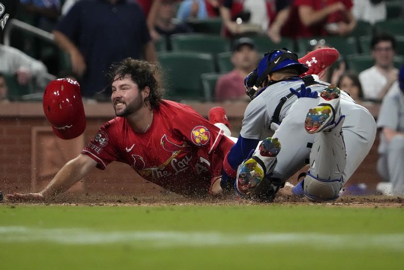 Alec Burleson, de los Cardenales de San Luis, anota frente al panameño Miguel Amaya, de los Cachorros de Chicago, el sábado 25 de mayo de 2024 (AP Foto/Jeff Roberson)