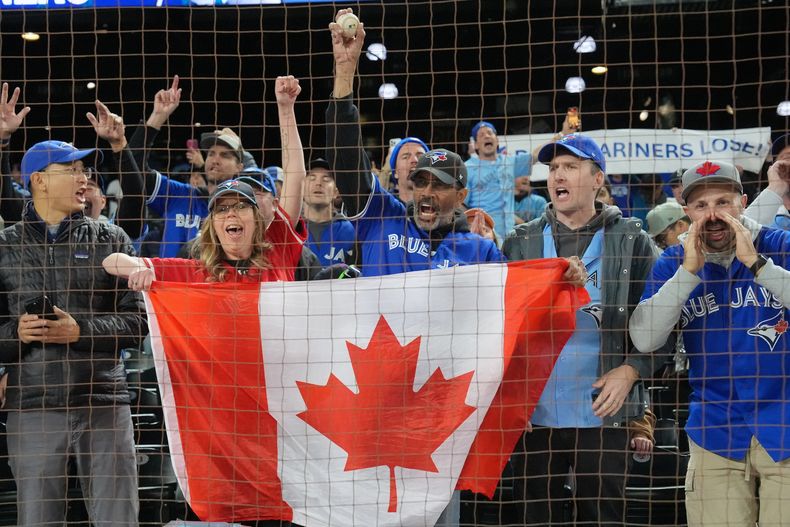 Aficionados de los Azulejos de Toronto celebran la victoria ante los Marineros de Seattle en el tercer juego de la serie de campeonato de la Liga Americana, el miércoles 15 de octubre de 2025. (Frank Gunn/The Canadian Press vía AP)